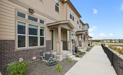 A row of houses with a sidewalk in front at The Townhomes at Pine Drive, Parker, CO, 80138