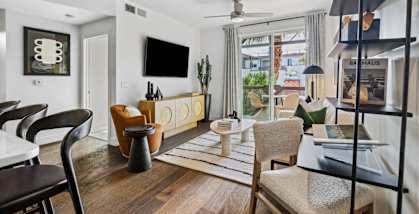 A living room with a flat screen TV and a glass door.