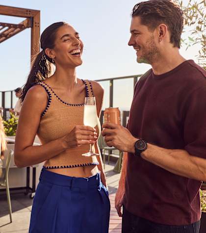A group of people are enjoying drinks on a rooftop patio.
