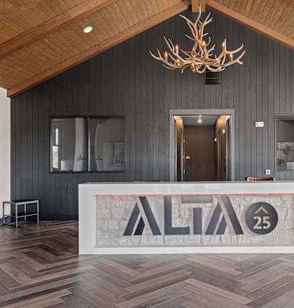 the lobby of alfa 25 with a reception desk and a chandelier at Alta25, Monument