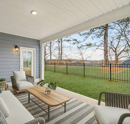 A patio with a sofa, chairs, and a coffee table.