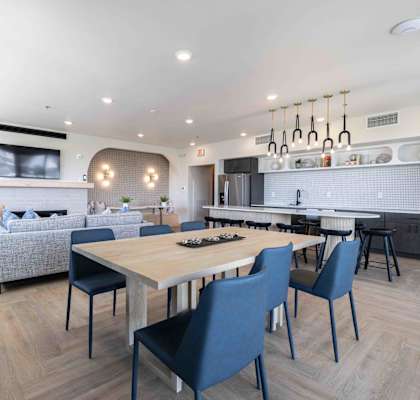 A modern kitchen with a dining table and chairs.
