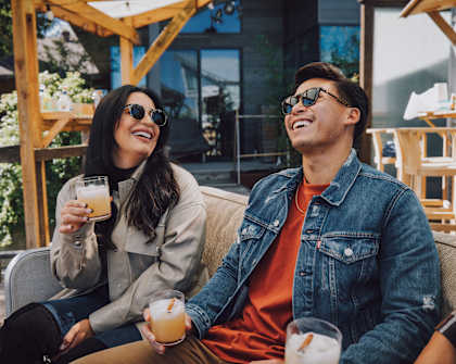 a man and a woman sitting on a couch with drinks