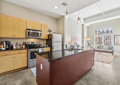 A kitchen with a refrigerator, oven, and microwave.