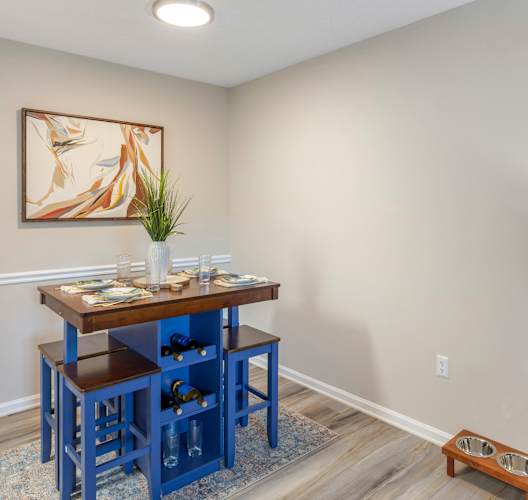 A dining room with a table and chairs.