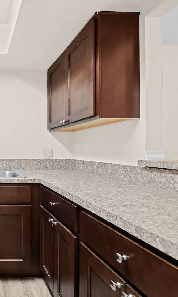 A kitchen with brown cabinets and a white stove top oven.