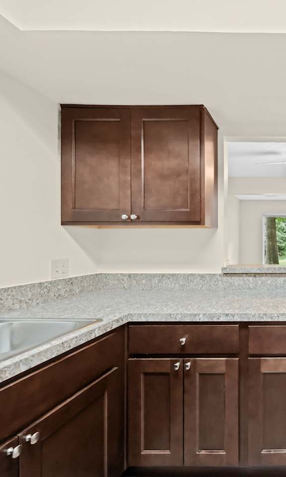 A kitchen with brown cabinets and a white refrigerator.