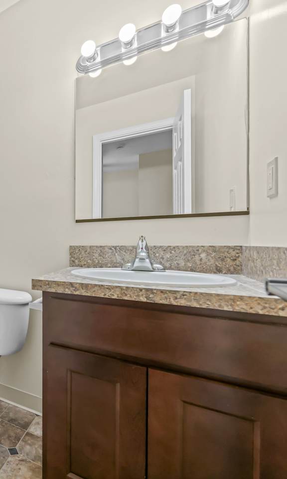 A white toilet sits in a bathroom next to a white bathtub.