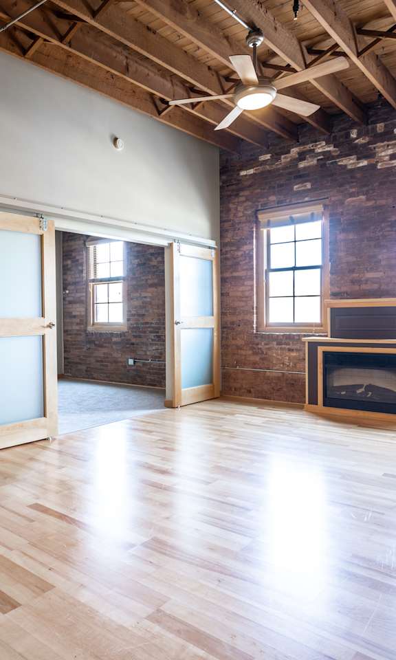 A room with wooden floors and a brick wall.