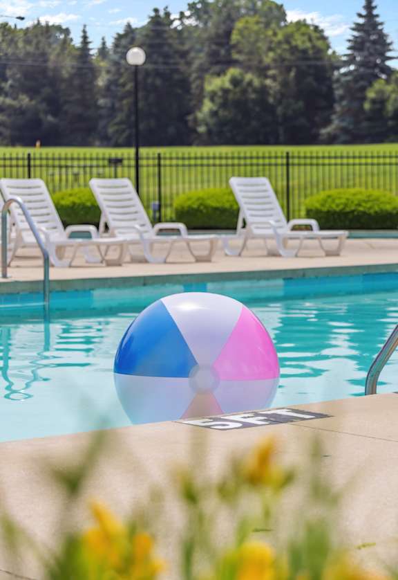 A pool with a blue and pink ball in the middle of it.
