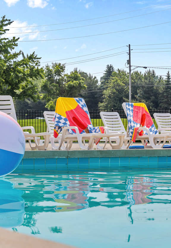 A pool with a blue and white beach ball in the water.