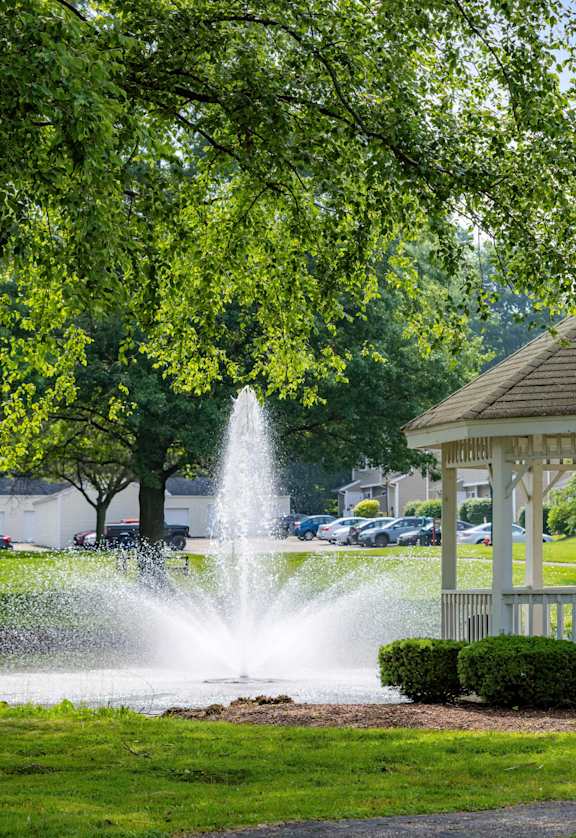 A gazebo with a fountain in front of it.