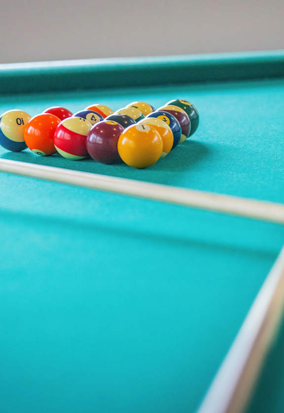 A pool table with a white ball and cues.