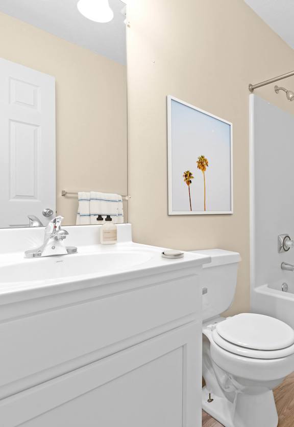 A white toilet sits next to a white sink in a bathroom.
