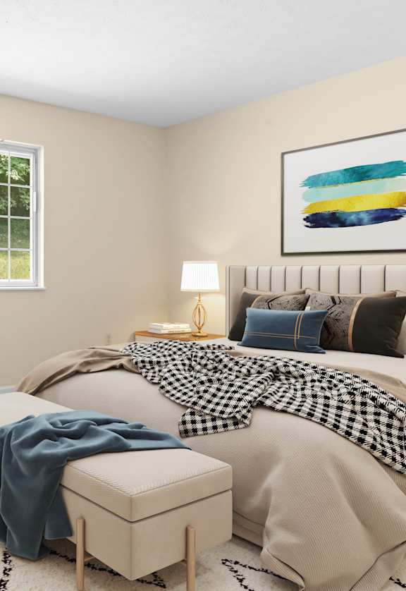 A bedroom with a bed, a bench, and two paintings on the wall.