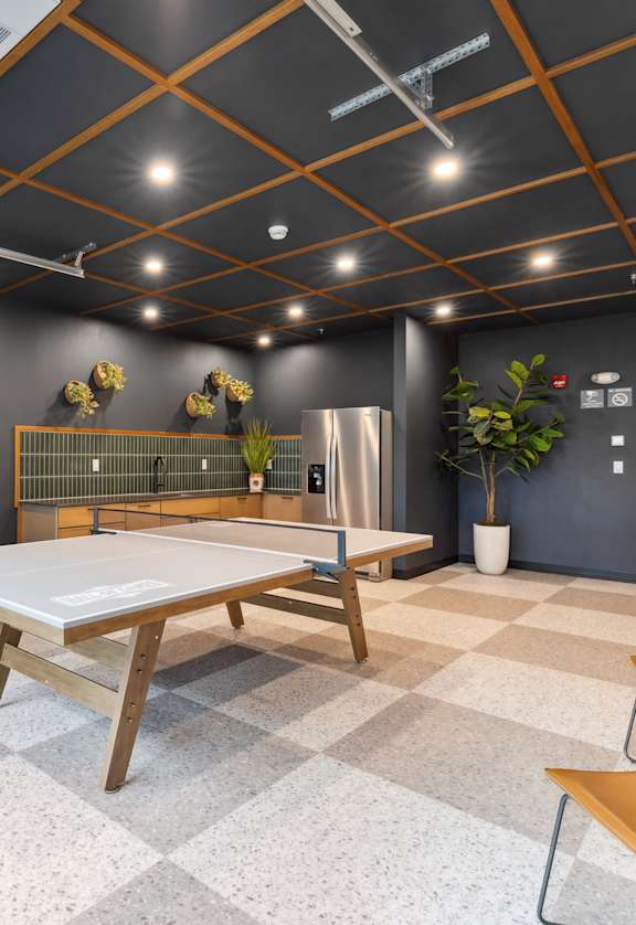 A room with a table, chairs and a fridge.