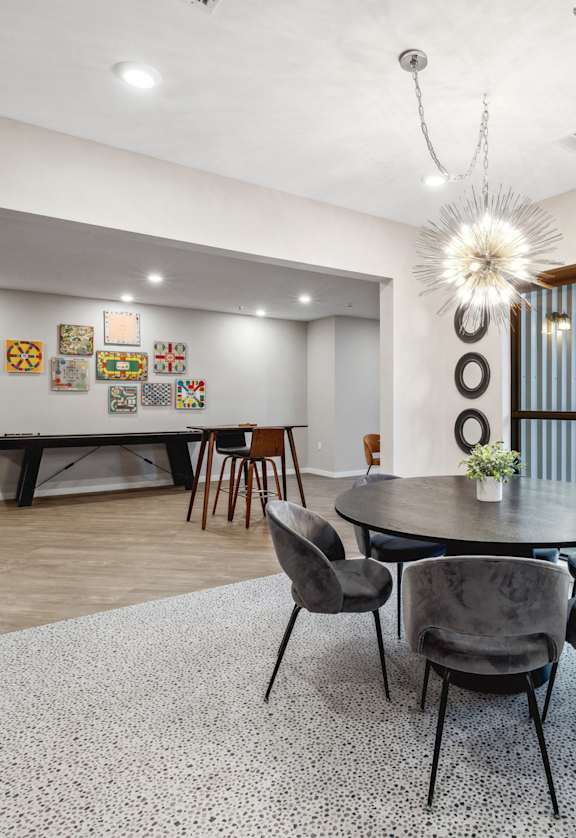 a dining area with a round table and chairs and a glass sliding door