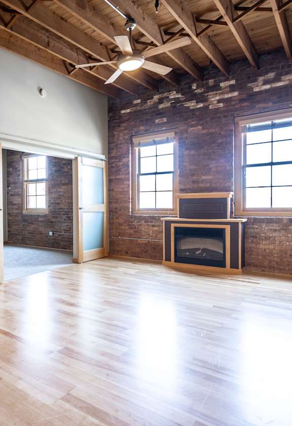 A room with wooden floors and a brick wall.