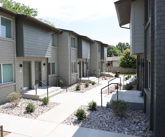 A row of modern townhouses with grey siding and white trim.