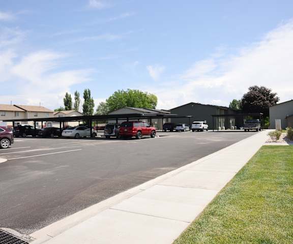 A parking lot with cars and a building in the background.