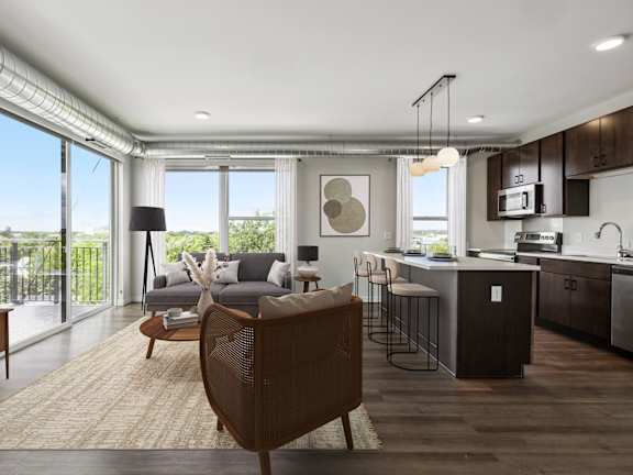 an open kitchen and living room with a large window and a balcony
