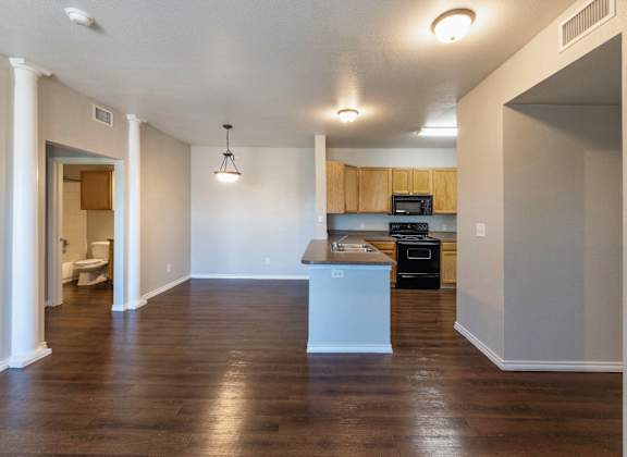 A kitchen with a white island and wooden floors.