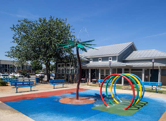 A playground with a blue pool and a slide.