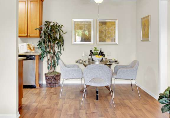 A dining room with a table set for four.