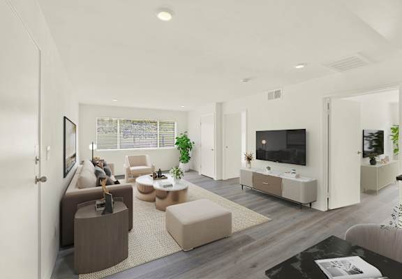 A modern living room with a large couch, a coffee table, and a television.
