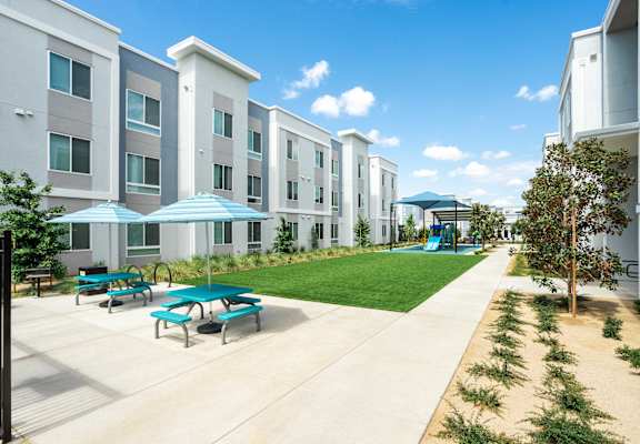 A sunny day at a modern apartment complex with a playground.