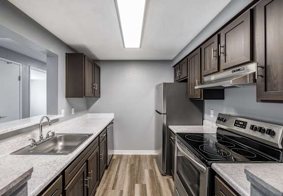A kitchen with a stove top oven and a sink.