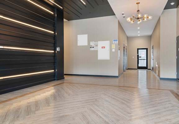 A hallway with a wooden floor and a ceiling light.