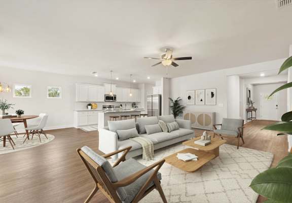 A modern living room with a white sofa, wooden chairs, and a coffee table.