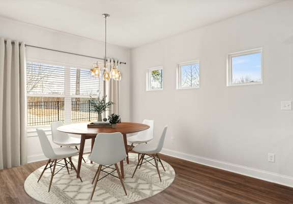 A dining room with a round table and chairs.