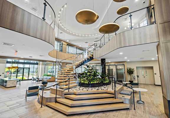 A modern atrium with a staircase and hanging lights.