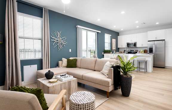 A modern living room with a beige sofa, a coffee table, and a potted plant.