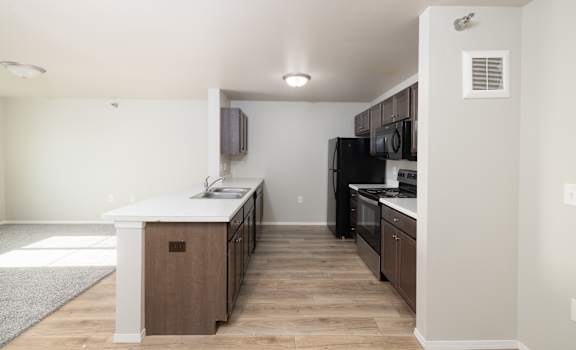 A kitchen with a white counter top and wooden cabinets.