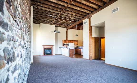 A room with a stone wall and a fireplace.