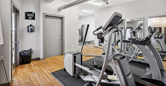 A gym with treadmills and a sign that says "Leave the office".