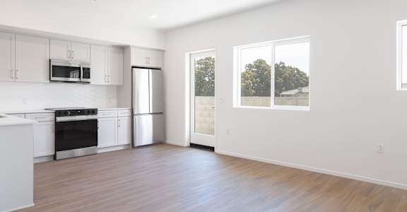 A modern kitchen with white cabinets and stainless steel appliances.
