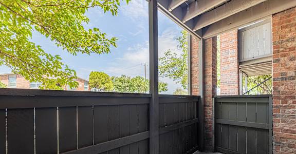A black fence with a brick wall and a window.