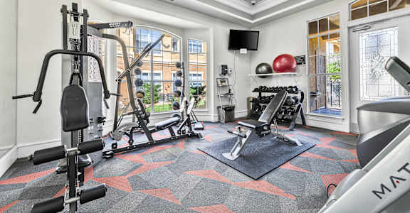 a home gym with exercise equipment and a window