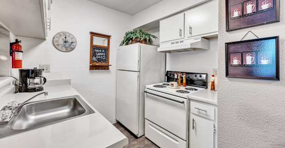 a kitchen with white appliances and a sink and a refrigerator