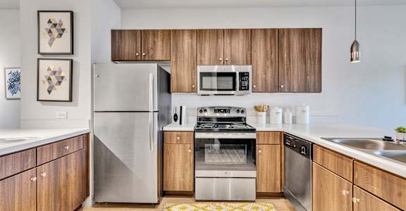 a modern kitchen with stainless steel appliances and wooden cabinets