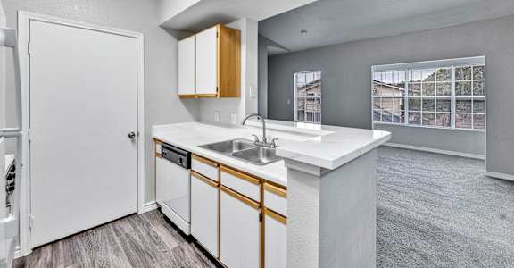 a kitchen with white cabinets and a sink and a refrigerator