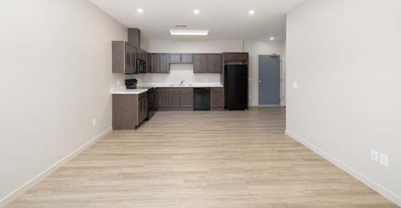 A kitchen with wooden floors and white walls.