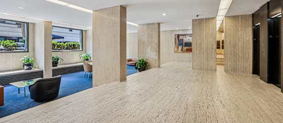 A spacious office hallway with wooden floors and columns.