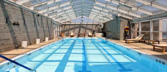 A large indoor swimming pool with a glass ceiling.