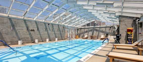 A swimming pool with a glass ceiling and a 3 feet deep sign.
