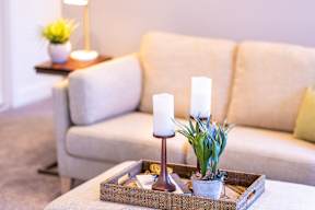 A table with a candle holder and a plant on it.